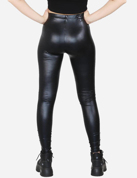Back view of black faux leather leggings on a model paired with combat boots, isolated on white.