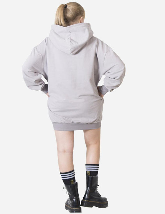 Back view of a woman in a light grey casual hoodie dress, showing a loose fit and hood detail, paired with sporty socks and black boots.