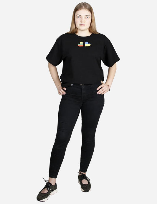 Young woman in black t-shirt with colorful heart emblem standing against a white background support Ukraina