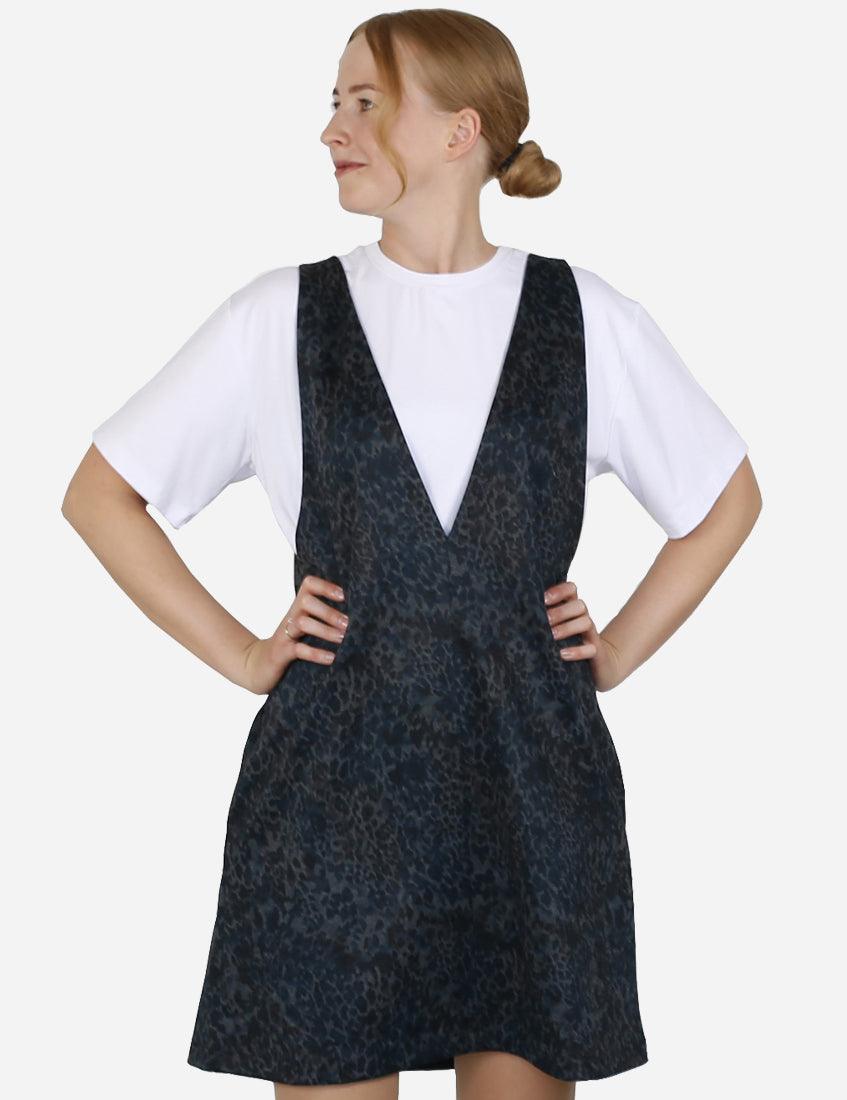 Blue patterned pinafore dress over a white t-shirt, with a focus on the unique pattern.
