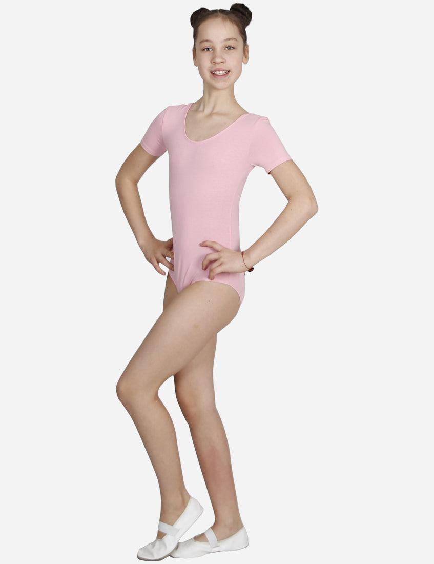 Cheerful young dancer wearing pink short sleeve leotard with white ballet shoes