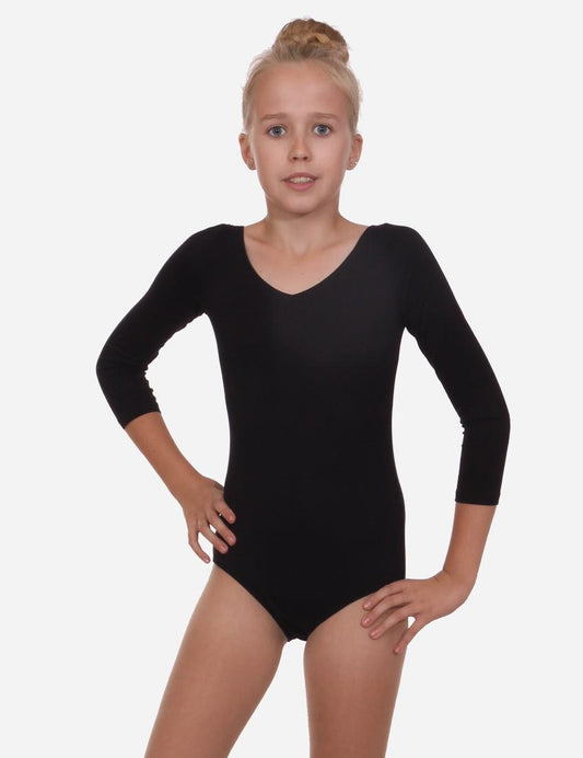 Child in a black leotard with half sleeves standing side view on white background