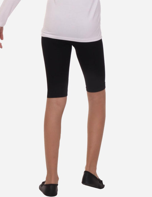 Partial view of child in white long sleeve top and black capri leggings on white background