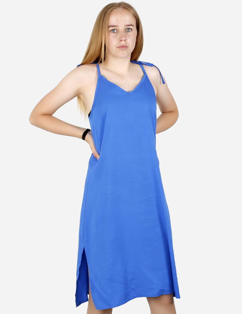 Confident young woman wearing a stylish royal blue dress with tie-up shoulder straps, posing with hand on hip, isolated on white background.