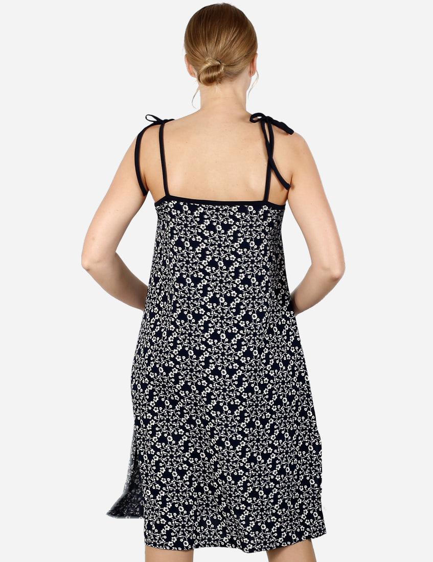 Back view of a floral dress with black tie-up straps on a woman.