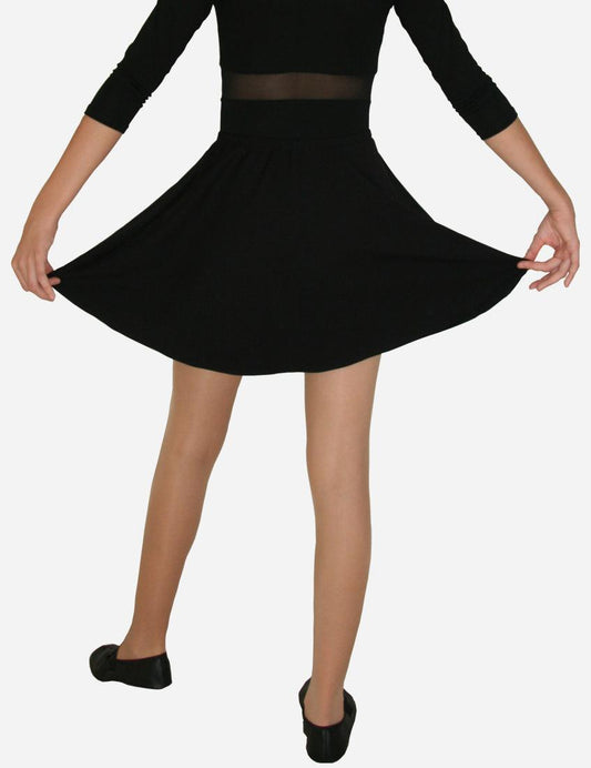 Young girl holding the hem of her flared black skirt, showcasing the full skirt design and ballet flats, isolated on a white background.