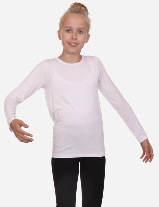 Young girl in a long sleeve white t-shirt and black shorts posing against a white background