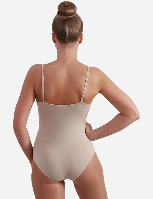 Rear view of a woman in a nude leotard with straps, hair styled in an elegant bun, showing the back design.