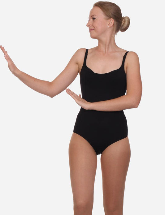 Woman in a stylish black leotard with straps, performing a ballet hand gesture, with a high bun hairstyle.