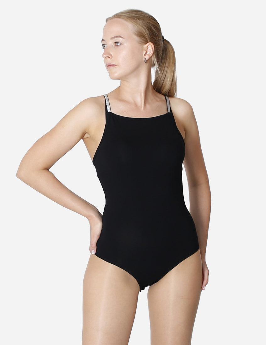 Woman in black leotard with sparkling straps viewed from behind on a white background
