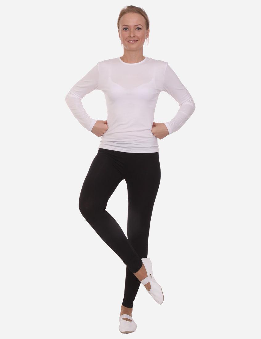 Full-body view of a woman in black leggings and a white long-sleeve top, standing confidently