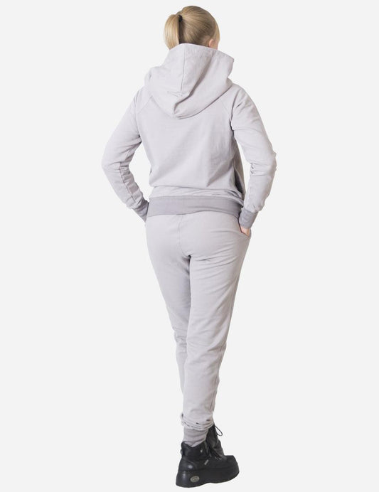 Back view of a woman wearing a stylish grey tracksuit with a hoodie, casual and comfortable fashion for active wear.