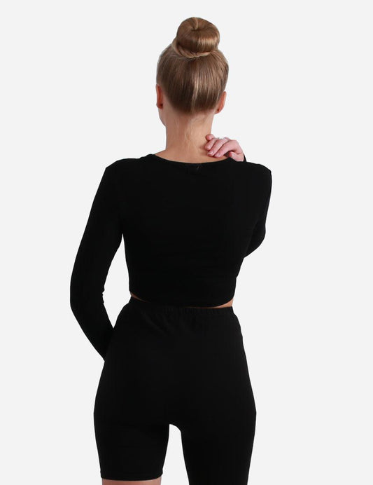 Back view of a woman wearing a long sleeve black cropped top on white background