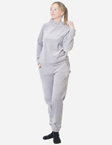 Woman in a luxurious grey velvet tracksuit looking contemplatively to the side, full-length image showcasing the soft texture and comfortable fit.