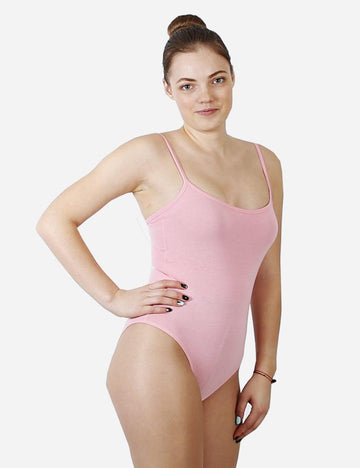 Woman in pink tank leotard with ballet hair bun posing for a dance class, front view