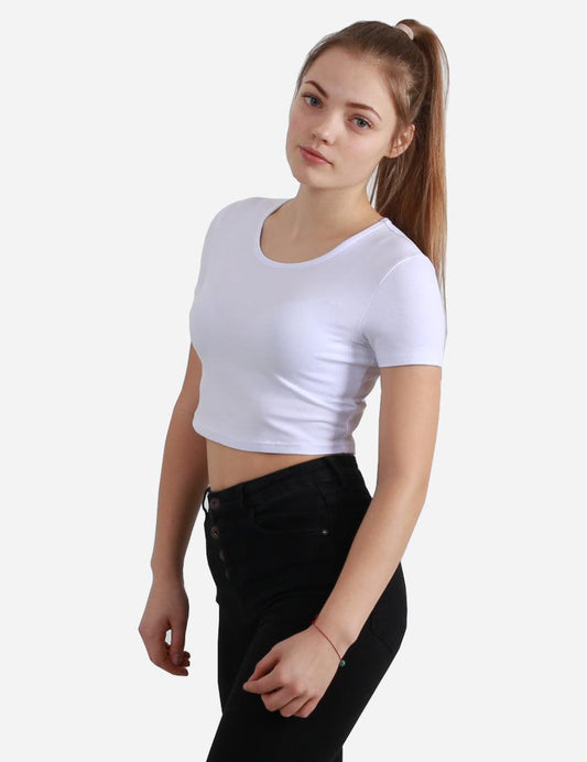 Woman in a white short sleeve cropped top looking to the side, paired with black high-waisted jeans on white background