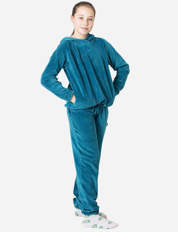 Confident young girl posing in a vibrant electric blue velvet tracksuit, complete with whimsical avocado-patterned socks.