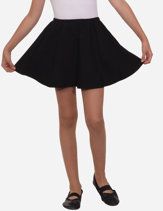 Young girl in a flared black skirt and white tank top posing with hands down, black ballet flats, isolated on white background.